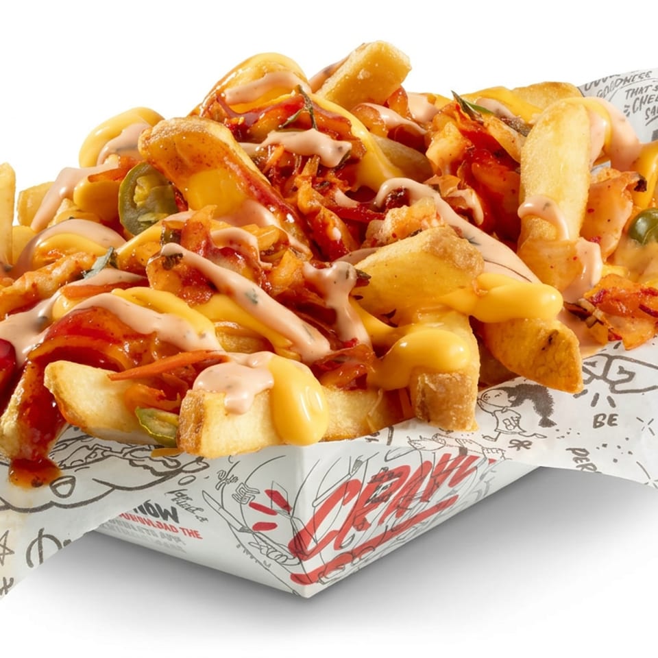 Loaded fries topped with melted cheese, bacon, jalapeños, and creamy sauces in a branded paper tray.