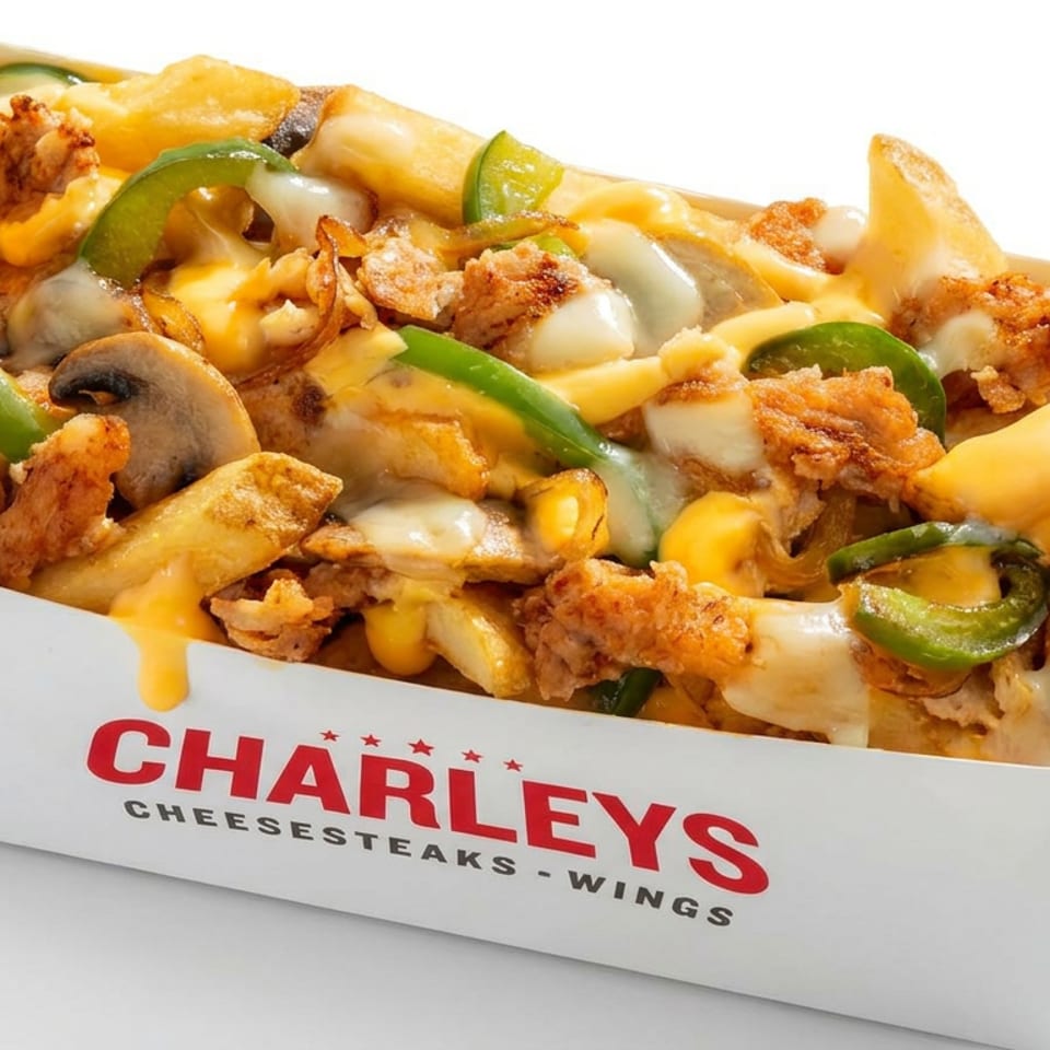 Loaded cheese fries topped with mushrooms, green peppers, onions, and crispy chicken in a Charleys Cheesesteaks box.